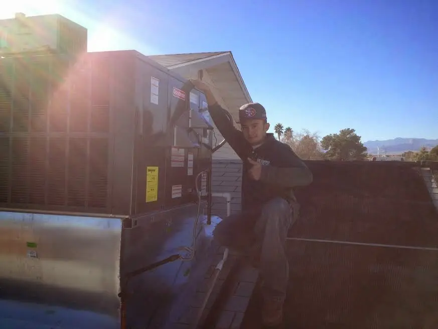 HVAC technician performing Heat Pump Repair on a rooftop unit in Oak Grove